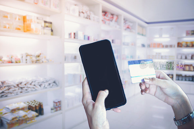 亚洲女性使用智能手机和信用卡在网上购物，选择性地专注于手头