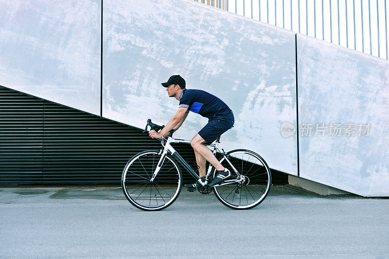一个男人骑着赛车穿过城市的侧视图肖像