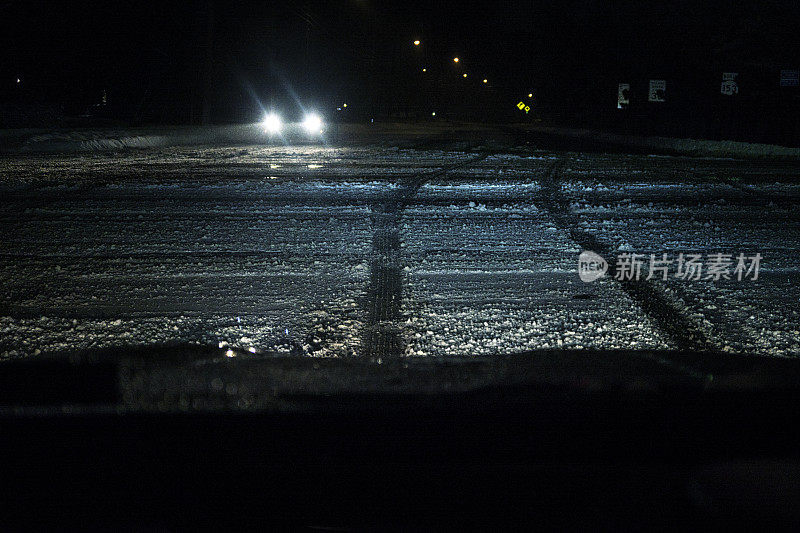 对面的汽车在等待红灯在冬季暴风雪