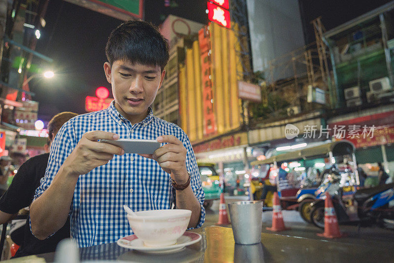 年轻的亚洲男人喜欢在泰国曼谷的中国城Yaowarat街旅游