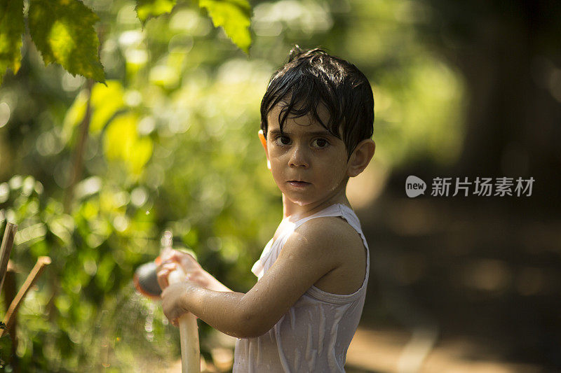 幼童在夏天在户外玩水管