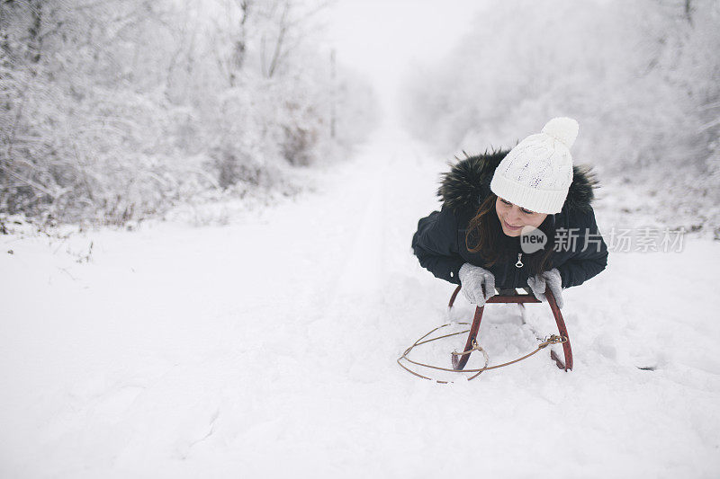 年轻女子在深雪中玩雪橇