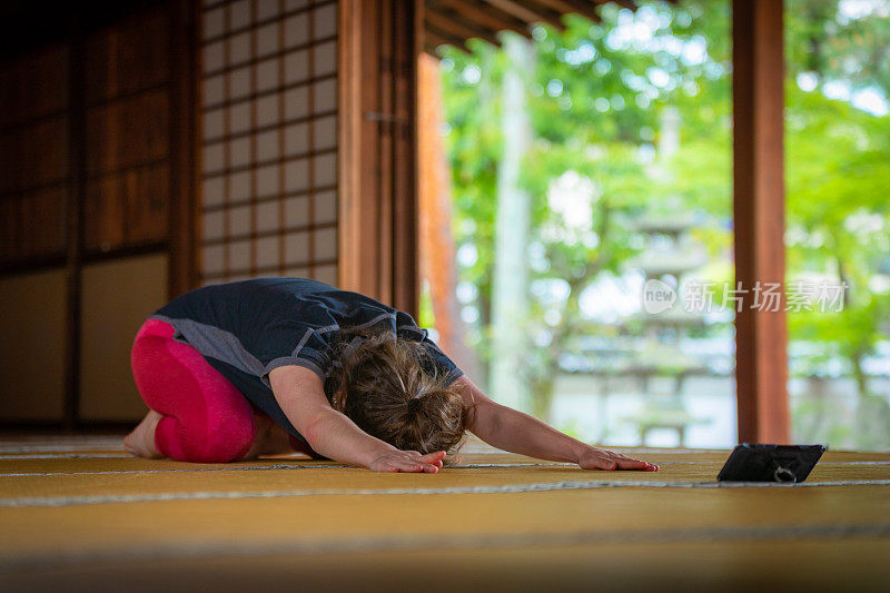 白人女性喜欢在寺庙里用智能手机练瑜伽