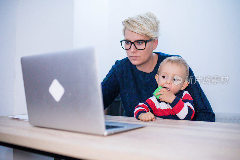 商业，母亲，多任务，家庭和人的概念-快乐微笑的商业女性与婴儿和笔记本电脑在办公室工作