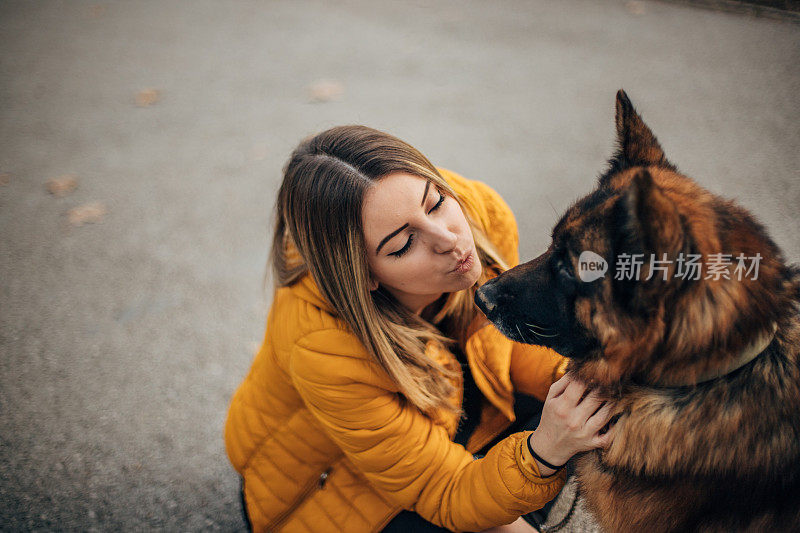 年轻女子和德国牧羊犬在公园里玩