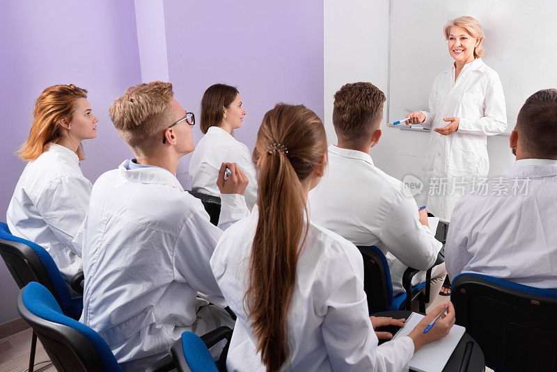 一群医学生在课堂上专心听女老师讲课