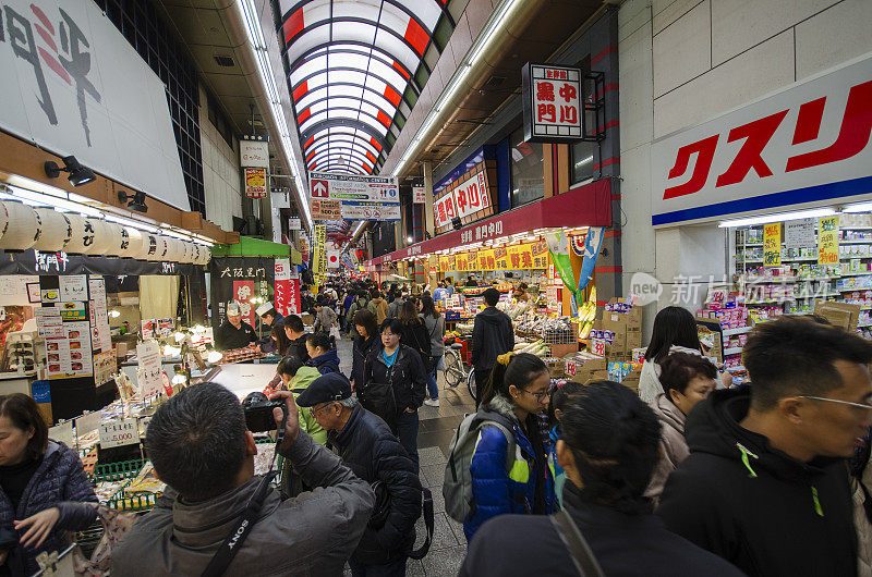 在大阪，购物者正在参观日本桥黑门市场