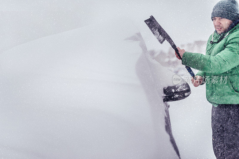 暴风雪把他的汽车盖上了雪