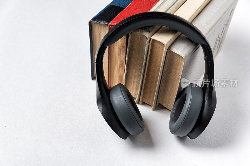 耳机和白色背景的一堆书。有声图书馆有声图书概念。