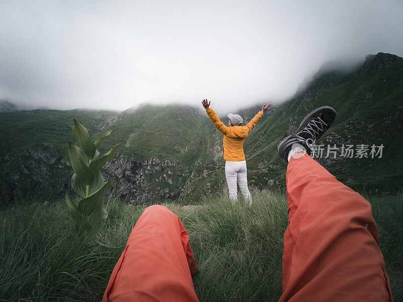 从个人角度看一个人，脚在框架里。回归自然。徒步旅行的游客夫妇在山上看美丽的景色。2019冠状病毒病大流行后的夏日户外享受。社会距离。