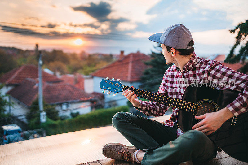 一个年轻人在阳台上弹吉他