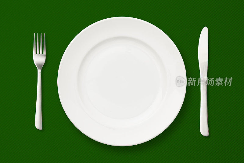 在绿色桌布上放置餐具。