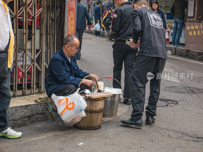 不熟悉的资深人士在街上卖豆腐在中国湖南长沙市的早上。太平老街是长沙市的标志性建筑之一