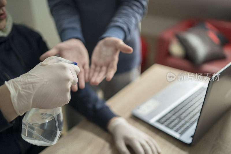 同事在工作前消毒双手，以防止冠状病毒的传播