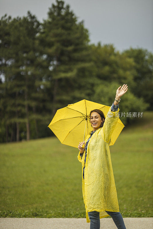 快乐的女人微笑着行走在雨天