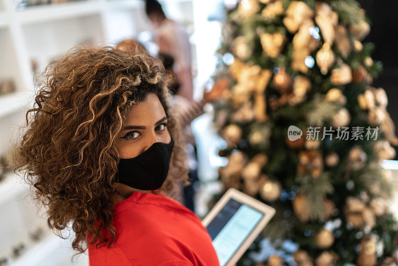 圣诞饰品店一位拿着平板电脑的女售货员的肖像