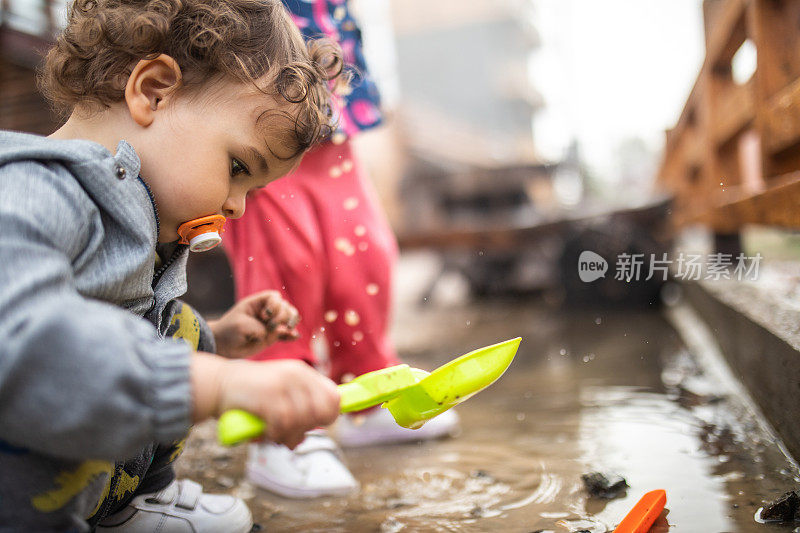 秋日雨后，小男孩在水坑里玩水