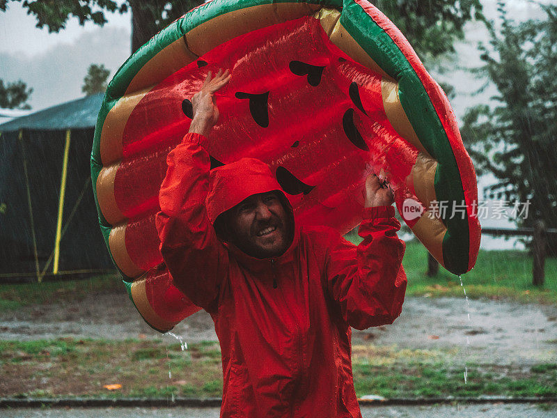 一名男子在露营时被困在暴风雨中，用充气木筏盖住