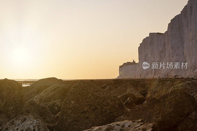 日落时的海滩岬悬崖和贝尔图特灯塔