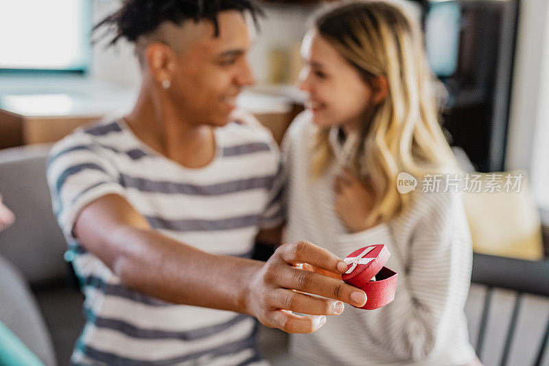 一个年轻的男孩在情人节给一个女孩订婚戒指的特写