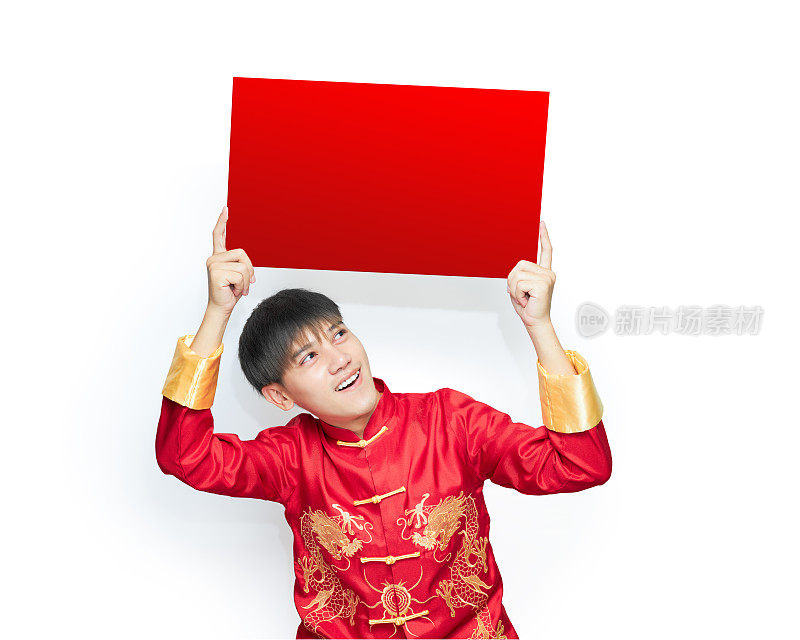年轻的亚洲男子穿着红色的马褂，兴奋地与纸标语牌，上面有空白的文字。