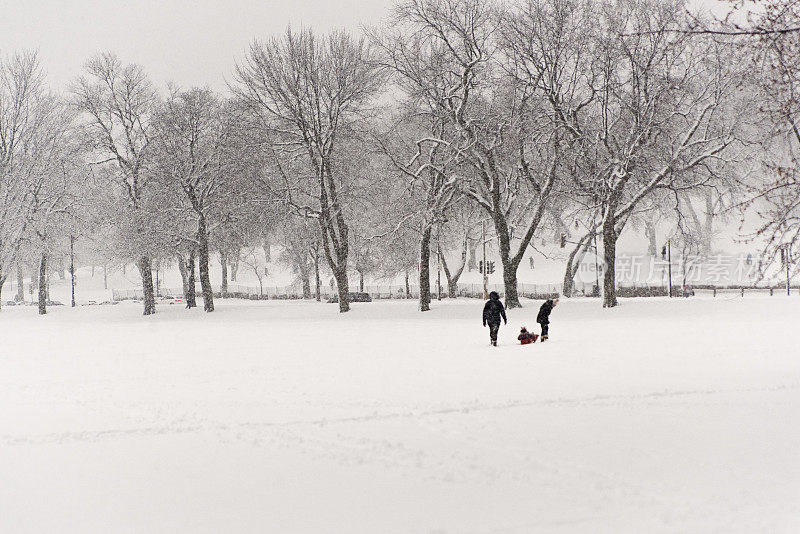 城市公园景观与不明身份的人在暴风雪。