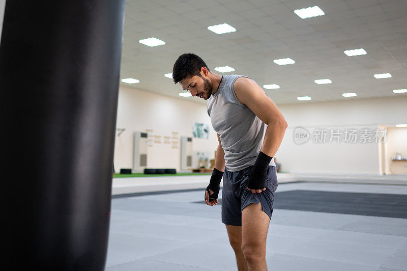 在拳击或拳击训练中击打拳击袋的男性拳击手