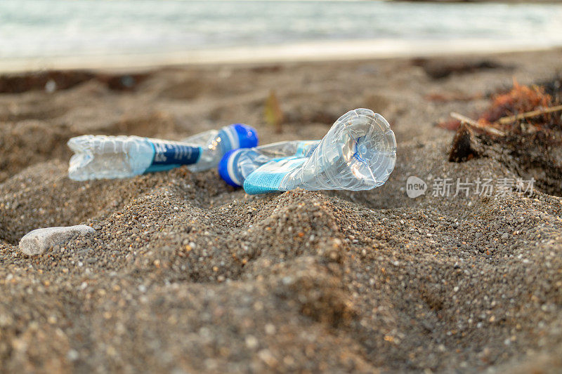 海滩上的空的用过的脏塑料瓶