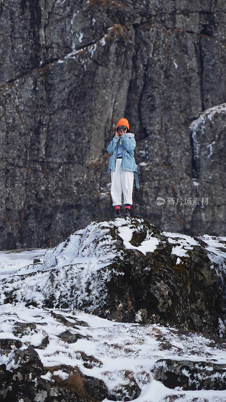 一个女人在寒冷的天气里穿行于白雪覆盖的山林之中