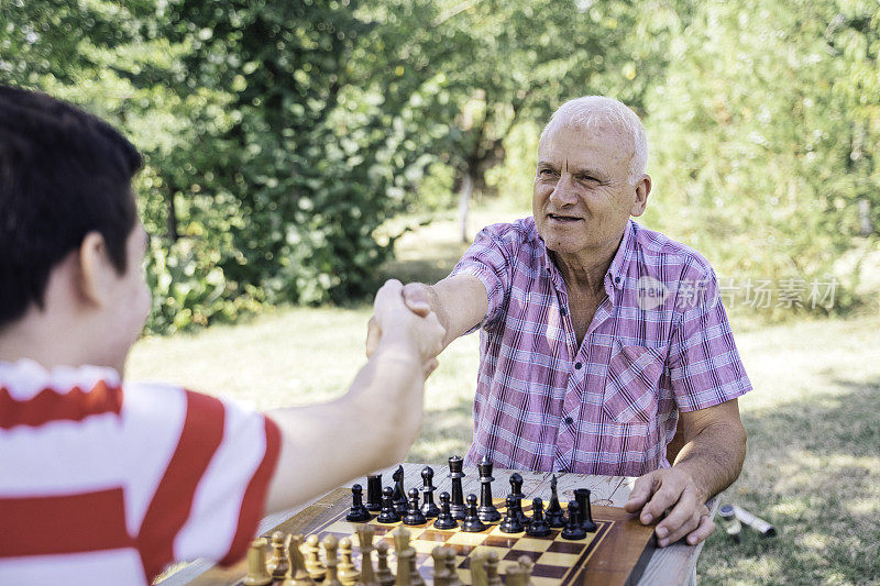 爷爷和孙子在一起下棋。