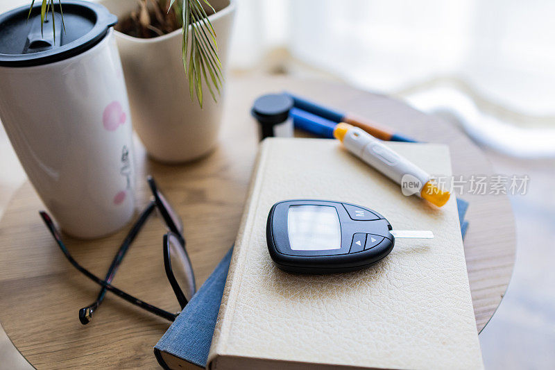 在家检查血糖水平。家庭手指刺血检查糖尿病控制。数字血糖仪和胰岛素笔。