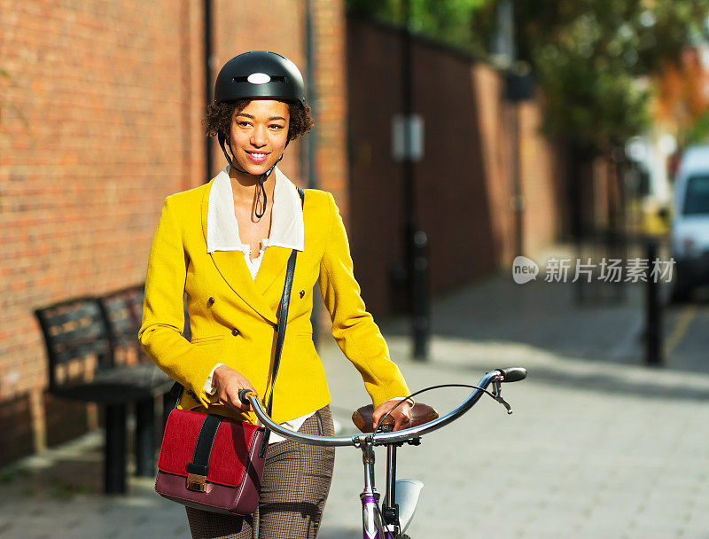 在城市里推着自行车的年轻女人