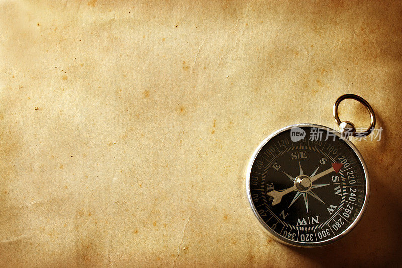 一个老式的指南针放在一个没有被使用的木桌上