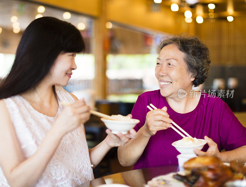 快乐的女儿和年长的母亲喜欢在餐厅吃饭