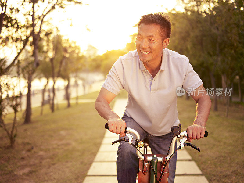 日落时分，在户外骑自行车的亚洲人