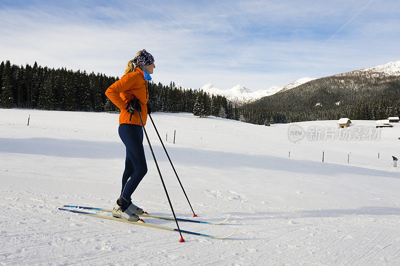 年轻女性越野滑雪运动员在斜坡上摆姿势