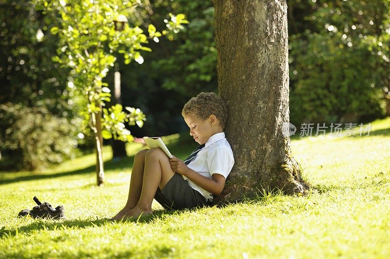 混血小男孩在外面读书写字