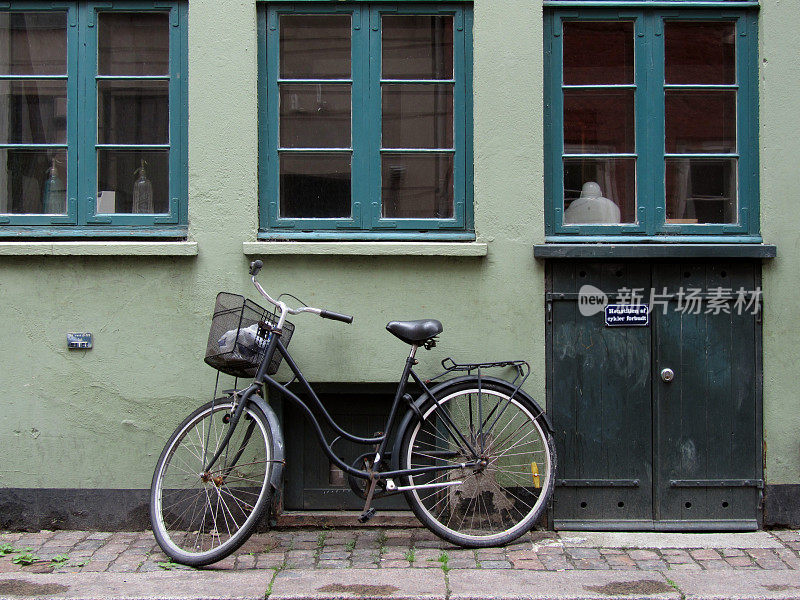 自行车靠在一堵绿色的墙上