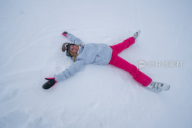 年轻女子躺在雪地上玩雪天使