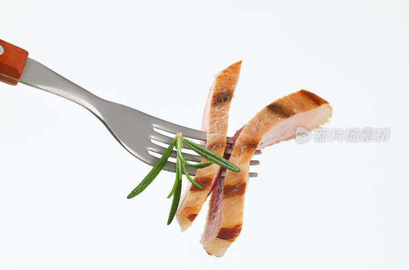 用叉子叉上百里香的半熟猪肉片