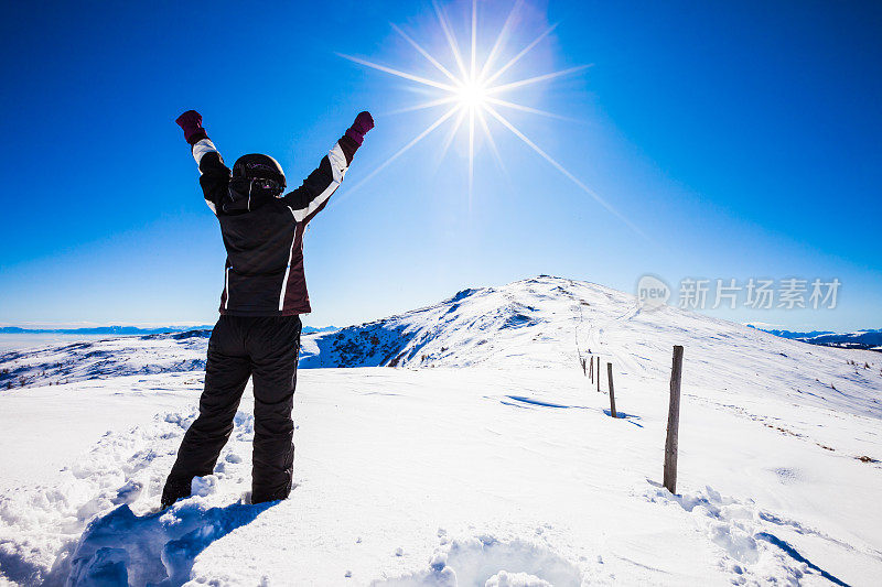 在滑雪场顶端的快乐的女人滑雪者