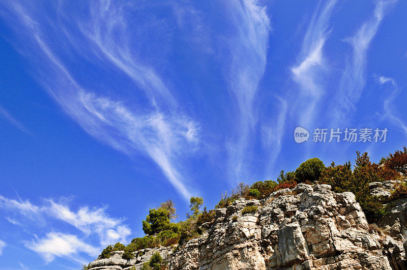 岩石峭壁和树木在蓝天