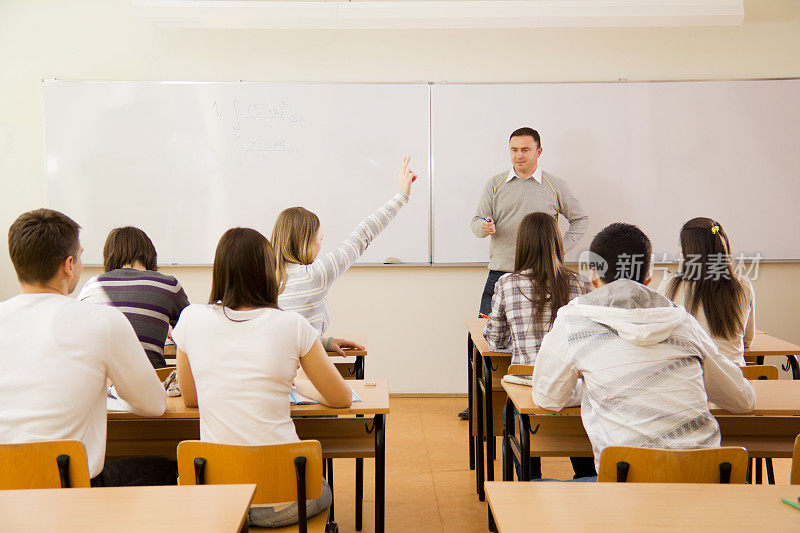 高中学生在教室里，女孩回应老师的