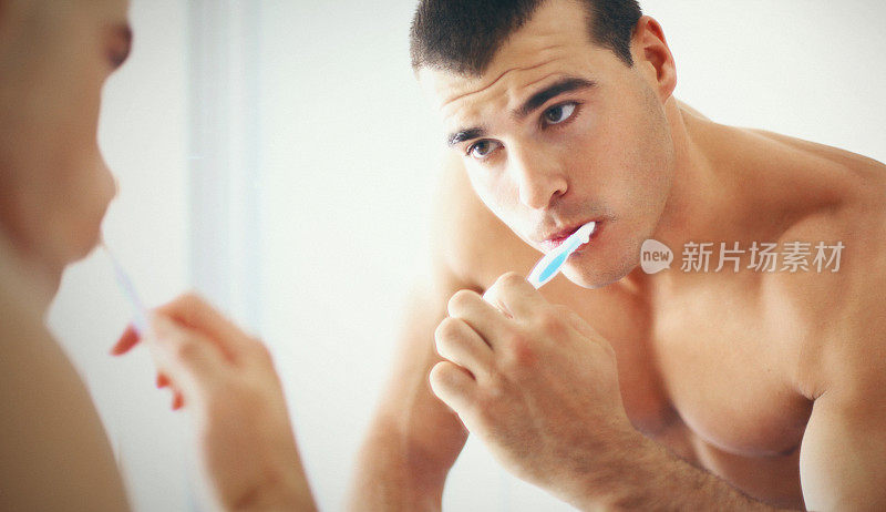 在浴室刷牙的男人。
