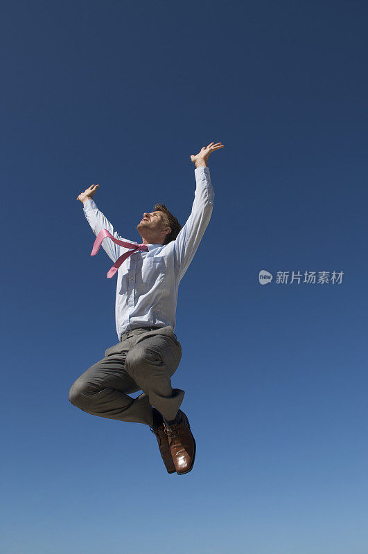 兴奋的商人在蓝天上庆祝成功