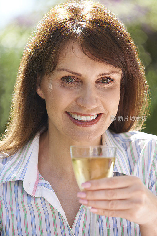 中年妇女享用一杯白葡萄酒