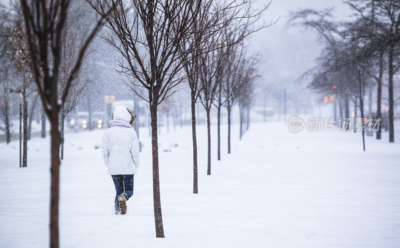 雪下穿着白色夹克的漂亮少女