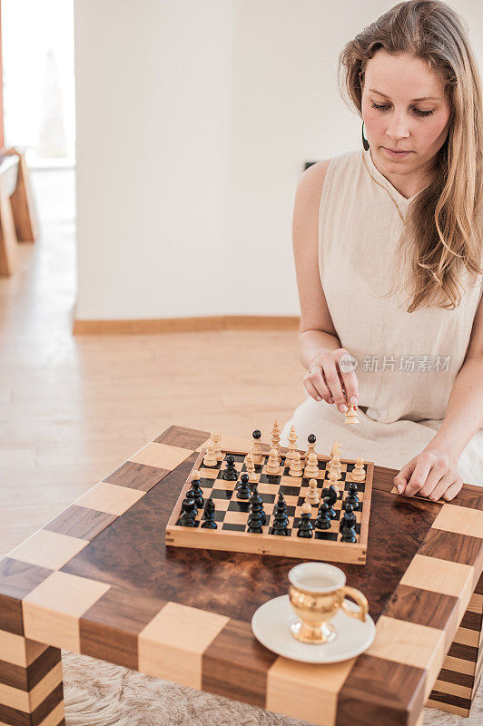 迷人的年轻女子在客厅下棋