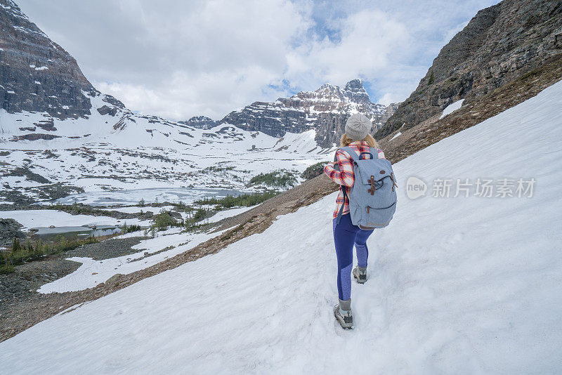 年轻女子在雪道上徒步旅行