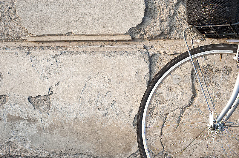 靠在旧墙上的自行车轮子